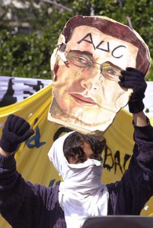 A student holds a drawing of President Alvaro Uribe with the letters AUC