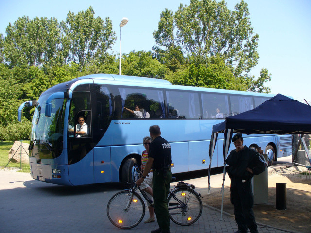 Een bus met delegatieleden verlaat het terrein