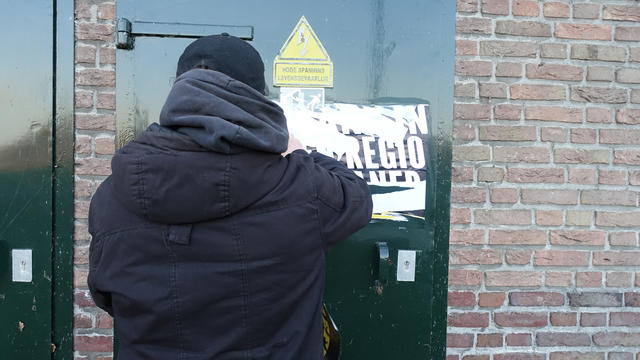 Mens verwijderd poster | Person removing poster