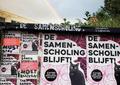 photo of the poster board at entrance of De Samenscholing with rainbow behind it